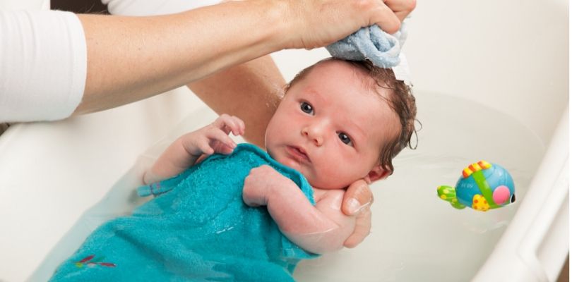 A baby getting a bath.